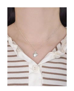 Close-up of minimalist S925 silver heart necklace worn on collarbone for women