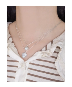 Detail of layered S925 silver necklace featuring heart pendants with zircon stones
