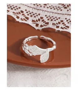 Macro detail of silver fishtail open ring with intricate fin texture and wavy band