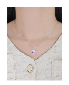Macro detail of S925 silver heart necklace with cherry-style pink zircon stones
