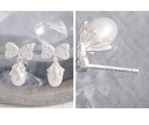 Macro detail of S925 sterling silver stamp on bow-knot pearl drop earrings for women