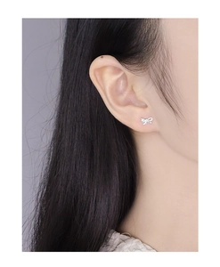 Close-up of asymmetrical S925 silver bow earrings with micro-inlaid sparkling zircon