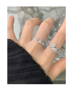 Detailed view of S925 silver rings with textured floral and leaf patterns on finger