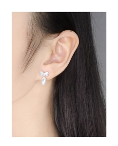 Close-up of S925 silver bow stud earrings with sparkling cubic zirconia and pearl drops