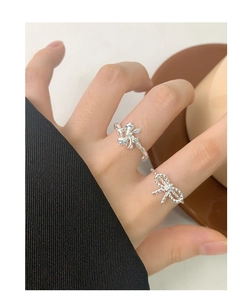 Close-up of S925 sterling silver bow rings worn on a hand with an adjustable open design