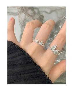 Detail of S925 sterling silver butterfly and floral open rings on a model hand