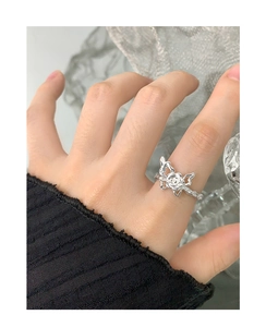 Detail of S925 silver ring featuring rose and butterfly motifs with textured finish