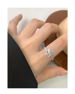Elegant silver s925 bow ring with irregular liquid metal texture worn on a finger