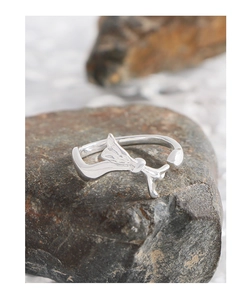 Artistic silver irregular ribbon open ring displayed on a natural raw rock background