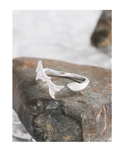 S925 sterling silver bow ring displayed on dark natural stone with soft lighting