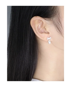 Close-up of S925 silver bow earrings with natural pearls and crystals on female model