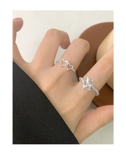 Detailed view of S925 silver irregular bow and intertwined heart rings on fingers