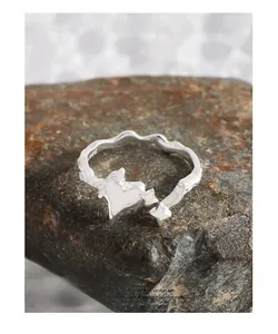 Macro shot of S925 sterling silver heart ring with star element on dark stone background