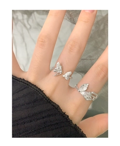 Close-up of S925 sterling silver butterfly wing rings with textured surface detail