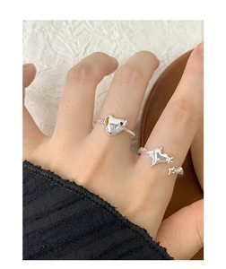 Detailed view of silver liquid lava heart and star ring worn on finger in minimalist style
