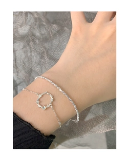 Macro detail of S925 silver double-layered moonstone bracelet with floral ring pendant