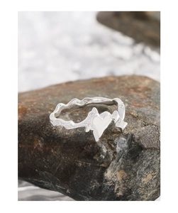Macro shot of S925 sterling silver heart and star ring on dark natural stone background