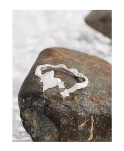 Macro shot of S925 sterling silver heart ring with star arrow on a brown rock
