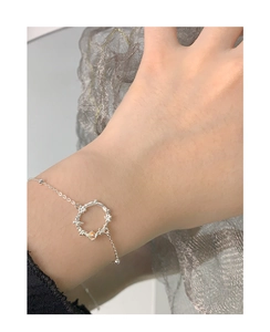 Detailed close-up of a sterling silver bracelet with a moonstone opal floral pendant