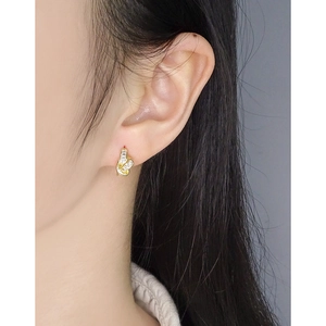 Elegant gold knot earrings with zircon stones shown on a model for daily wear