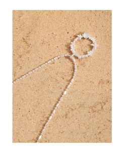 Detailed close-up of a S925 silver necklace with flower moonstone pendant on cork background