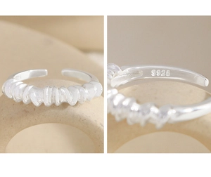 Macro shot of S925 sterling silver ring showing irregular twisted texture and hallmark
