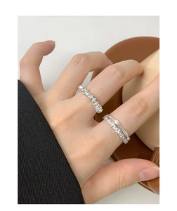 Detail of S925 sterling silver spiral rings and pavé zircon bands on a model's hand
