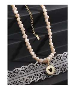 Detailed close-up of S925 silver stamp on baroque pearl necklace with heart charm