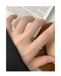 Close-up of a silver floral pattern ring showing fine flower details on the finger