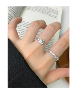 Close-up of double-layer irregular S925 silver rings with square pattern on book