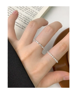 Close-up of S925 sterling silver minimalist flower rings stacked on fingers