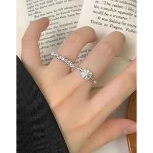 Irregular spiral silver ring for women featuring a textured square charm on a book background