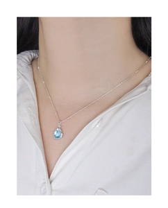 Gros plan d'un collier en argent S925 avec pendentif cristal bleu clair en forme de goutte