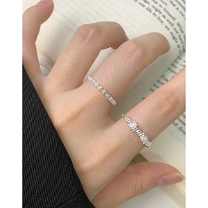 Minimalist S925 sterling silver flower rings set shown on a model hand with book background