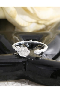 Macro shot of S925 sterling silver stamp and rose bud design on an open flower ring