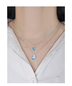 Détail du collier double couche en argent S925 avec pendentifs en cristal bleu en cœur