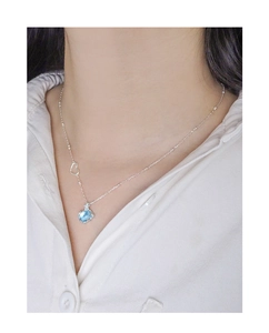 Gros plan sur collier en argent S925 avec détail cœur et cristal bleu de forme carrée