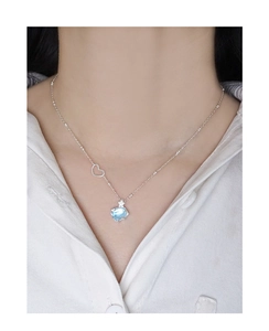 Détail du collier en argent S925 avec cristal bleu clair et cœur ajouré sur un mannequin