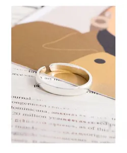 Detail of minimalist S925 sterling silver ring with polished finish on magazine background
