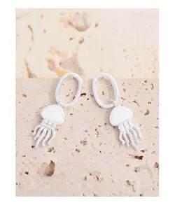 Détail macro des boucles d'oreilles méduse en argent S925 avec courbes et tentacules élégants