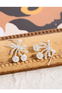 Close-up of S925 sterling silver cherry bow earring with hammered texture finish