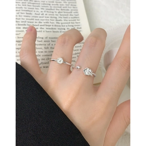 S925 sterling silver floral rings featuring sunflower and flower bud designs on a book