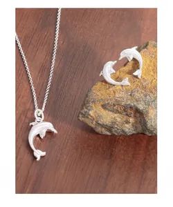 Detail view of S925 sterling silver dolphin necklace and stud earrings set on raw stone