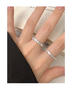 Close-up of S925 sterling silver ring set with faceted and smooth bands on hand