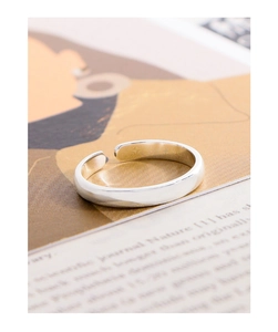 Detailed view of polished S925 sterling silver minimalist open ring on a magazine