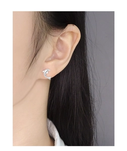 Close-up of S925 sterling silver dolphin stud earrings worn on female ear