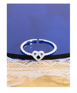 Detail of S925 sterling silver beaded ring with hollow heart design on lace background