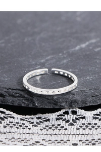 Detailed close-up of S925 sterling silver hollow heart ring on dark stone and lace