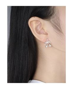 Close-up of S925 silver cherry bow earring with sparkling zircons worn by a model