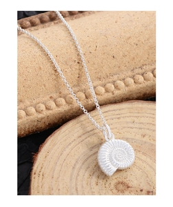 Vue détaillée du pendentif nautile en argent S925 avec texture spirale sur bois